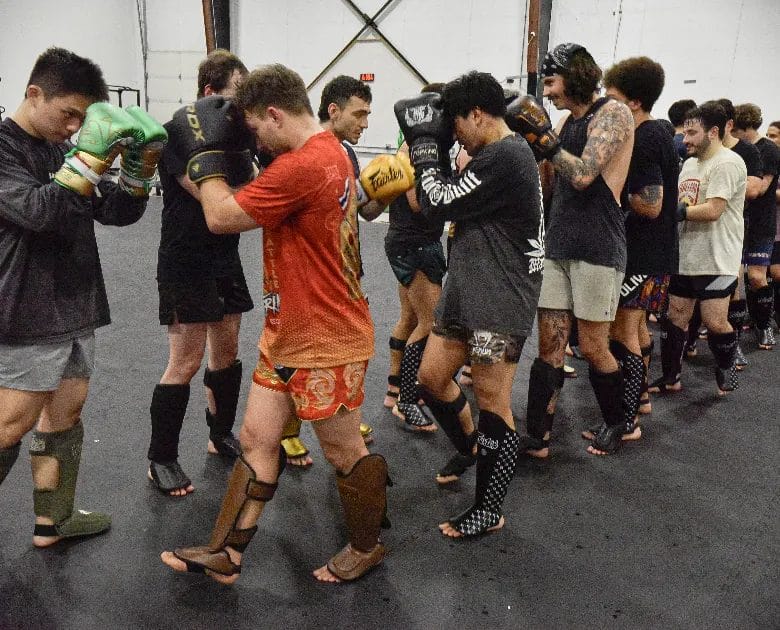 line of athletes practicing muay thai clinch technique together in class at Muaythai Iyarin